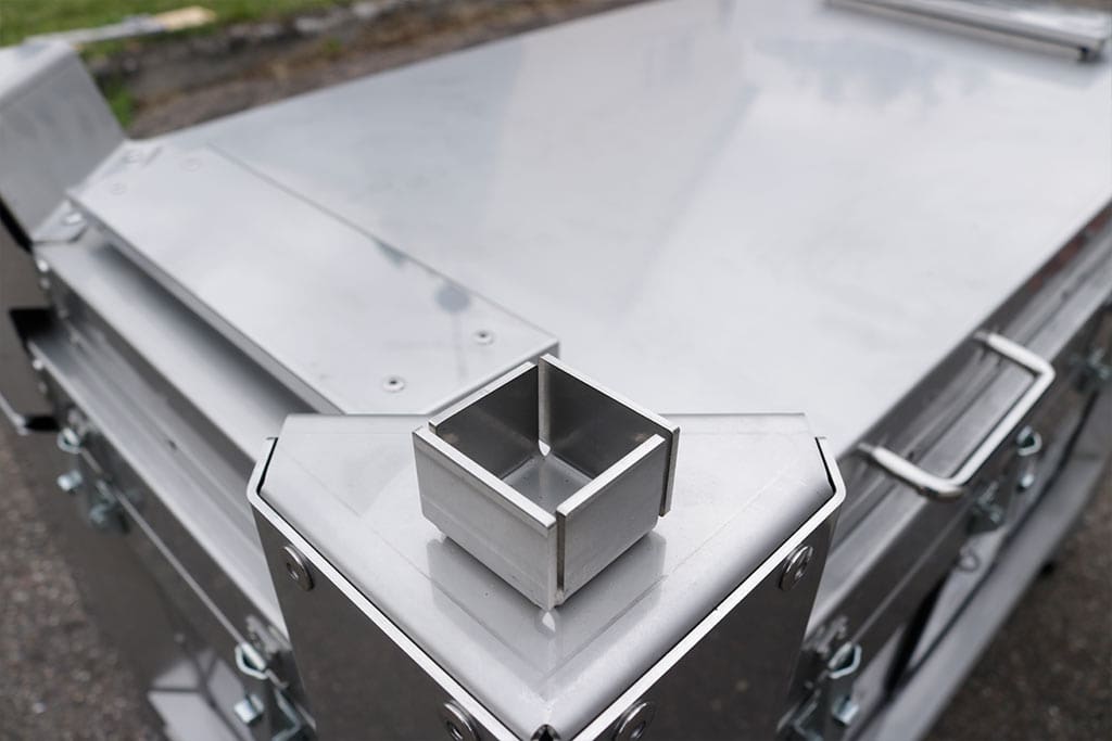 Cutie metalică industrială cu finisaj argintiu, formă angulară și detalii elaborate.